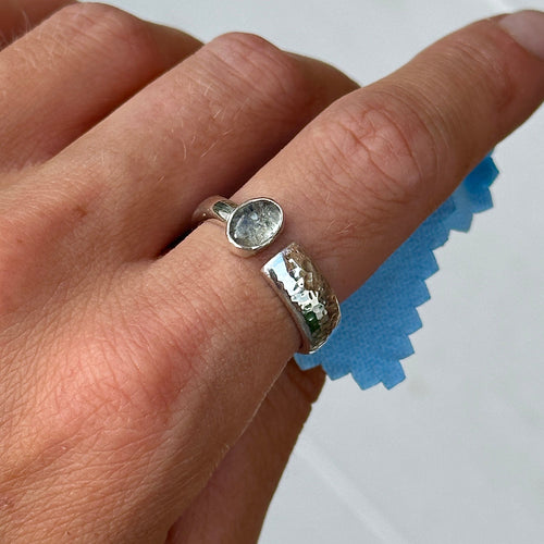 Close-up of a handmade memorial ashes ring with an aquamarine cabochon, crafted in recycled sterling silver.
